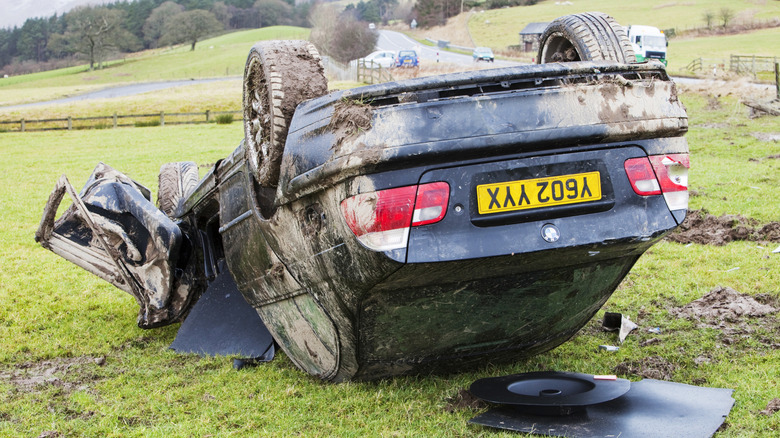 a flipped volkswagen car lying successful a field