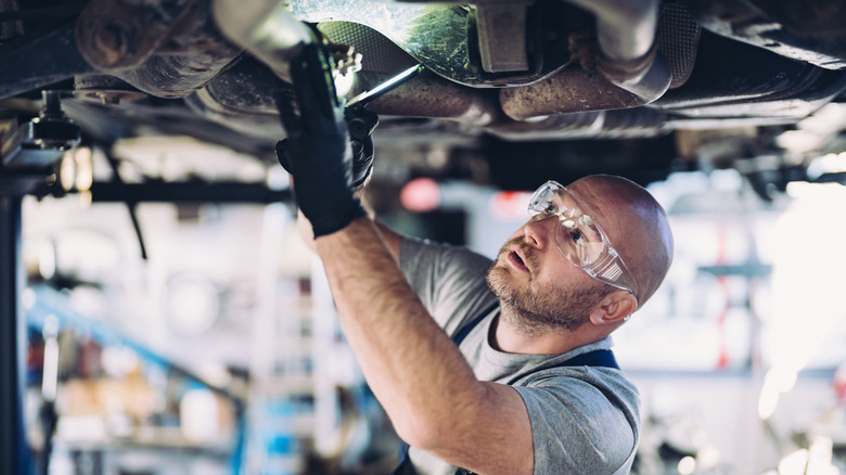 A mechanic working underneath a car