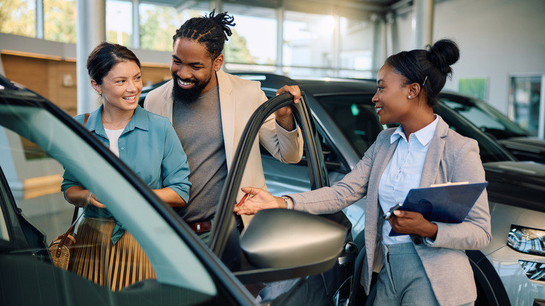 A salesperson with customers at a dealership.