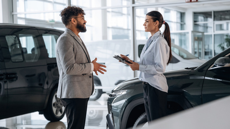 A salesperson with a customer at a dealership.