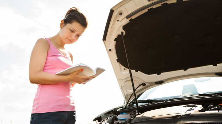 A woman reading her car's manual