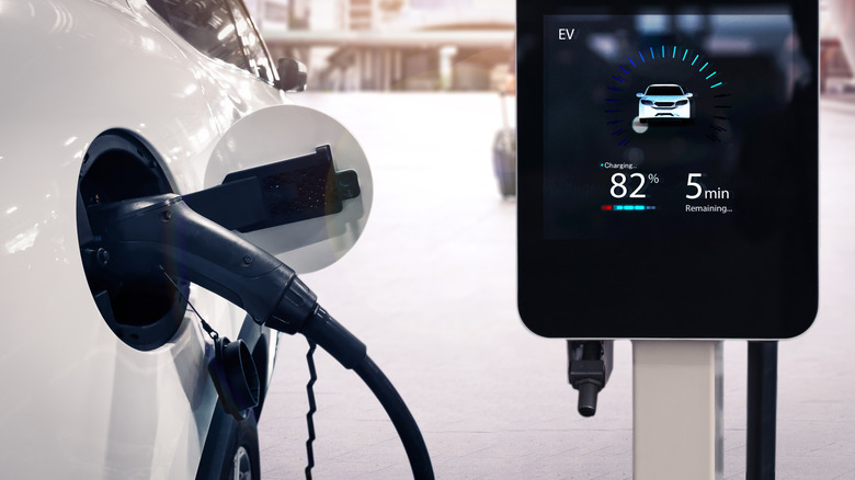 An electric car connected to a recharger showing an 82% state of charge