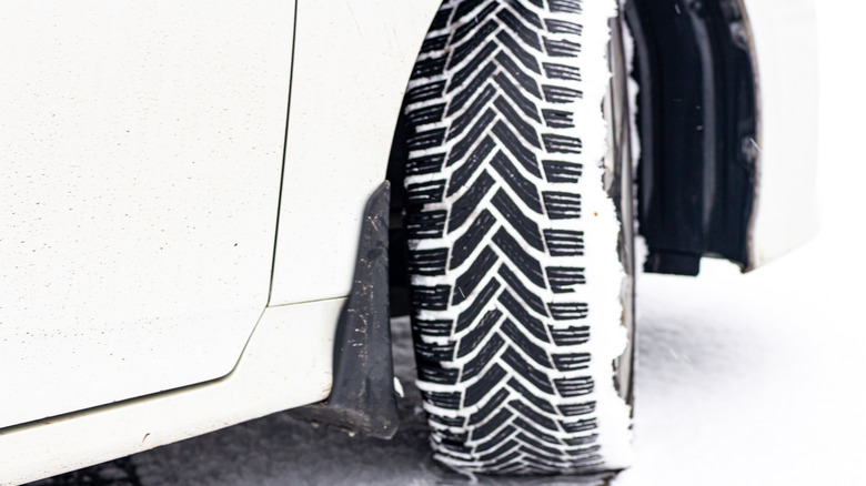 A white sedan with winter tires.