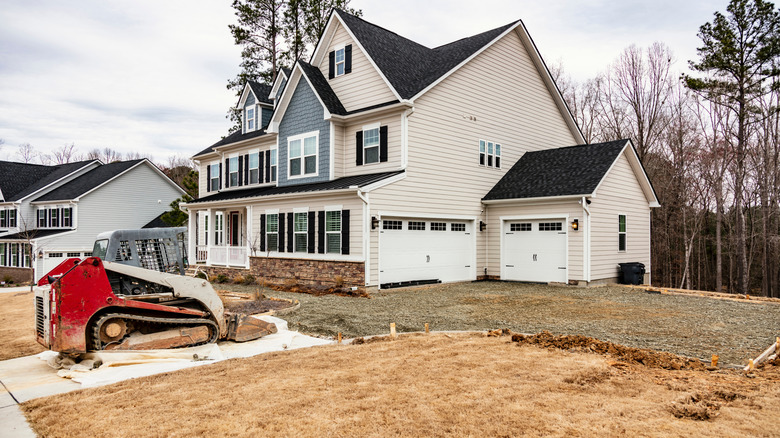 A picture of a residential housing development with preparation for a new driveway underway