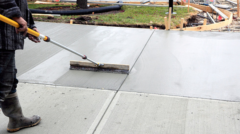 A person smoothing out freshly poured concrete