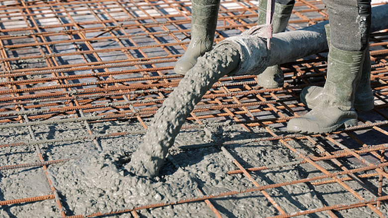 An image of people pouring to form a reinforced concrete driveway