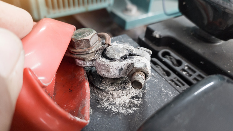 A car battery with white, powdery corrosion on a terninal.