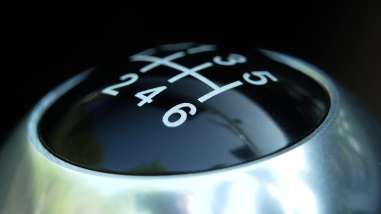 Close-up of a manual transmission gearshift knob with a six-speed pattern printed on it