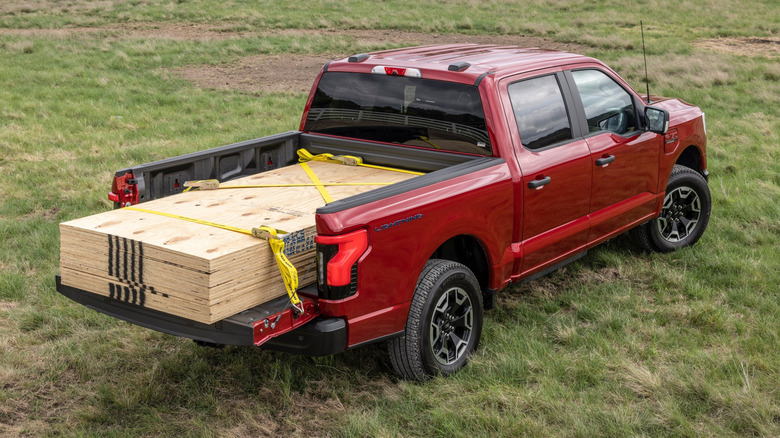 A Ford F-150 Lightning Pro Platinum with plywood in its bed
