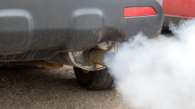 A close-up of a car with smoking exhaust fumes