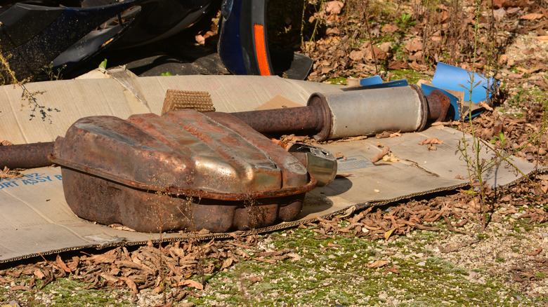 A catalytic converter and exhaust system lying on the grass