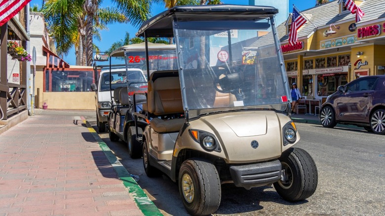 Golf cart parked connected a street.