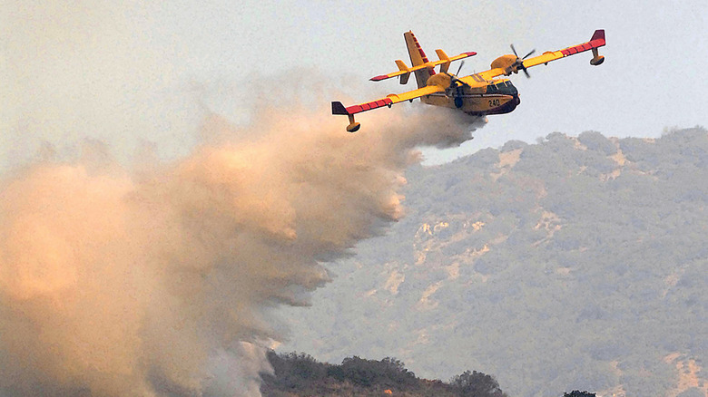 A Canadian built 'Super Scooper' firefighting aircraft makes a water drop while containing a fire in the foothills, November 24, 2007 in Malibu, California.