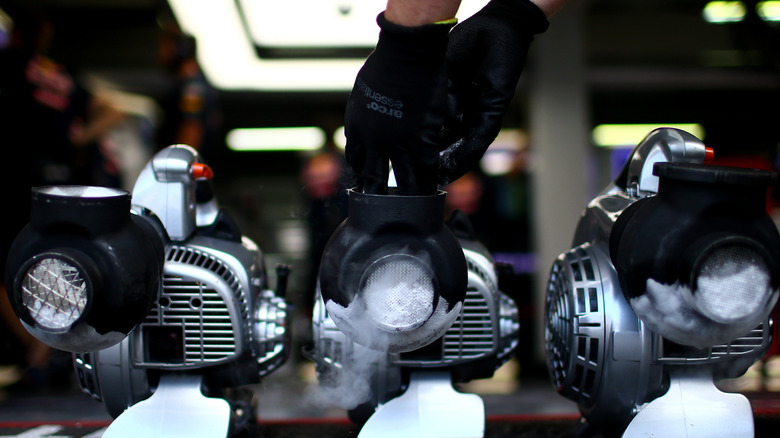 F1 mechanic loading dry ice onto a cooling fan.