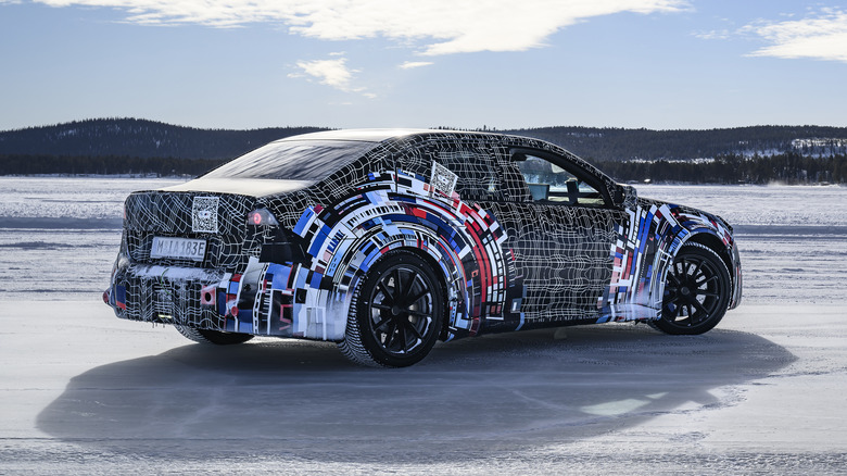 Rear 3/4 view of a camouflaged BMW M3 EV