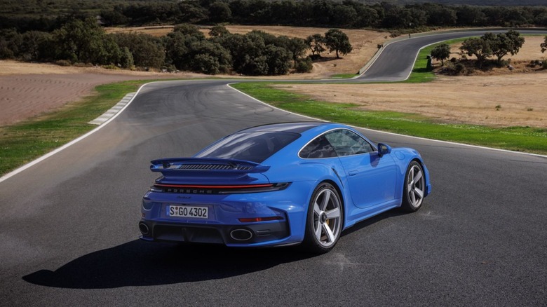 Rear 3/4 of 2026 Porsche 911 Turbo S parked on twisty road