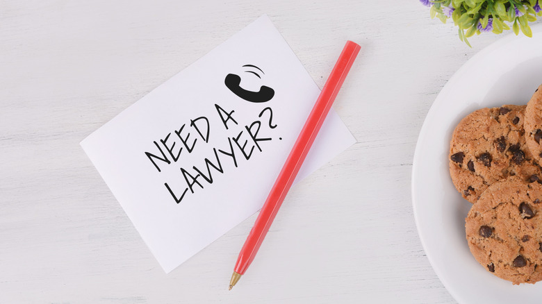 Stock image of a card with "NEED A LAWYER?" written on it next to a plate of chocolate chip cookies.