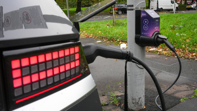 MANCHESTER, ENGLAND - OCTOBER 12: An electric car charges at an Amey lamppost charging point on October 12, 2026 in Manchester, England. Manchester City Council has partnered with Amey to pilot a scheme for EV chargers to be installed in street lampposts, offering charging points for residents without access to off-street parking. (Photo by Christopher Furlong/Getty Images)