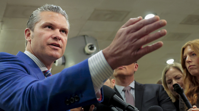 Pete Hegseth with his arm outstretched