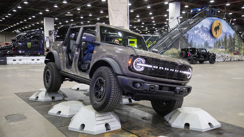 People ride through an obstacle course in a Ford Bronco at the Ford exhibit on the show floor at the 2026 Detroit Auto Show on January 14, 2026 in Detroit, Michigan.