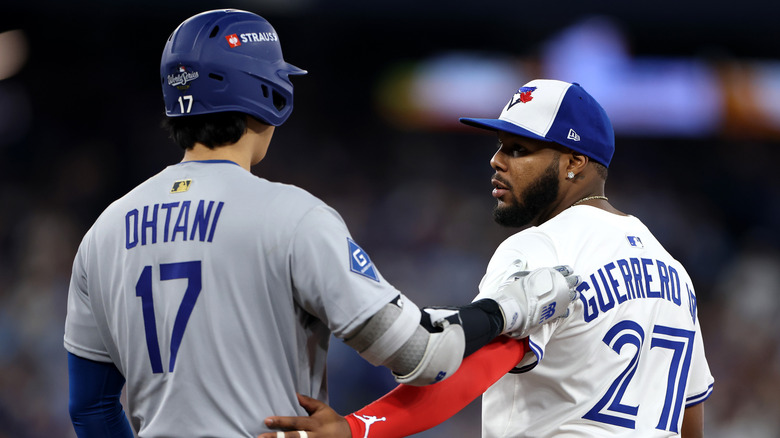 Shohei Ohtani #17 of nan Los Angeles Dodgers talks pinch Vladimir Guerrero Jr. #27 of nan Toronto Blue Jays during nan eighth inning successful crippled 2 of nan 2025 World Series astatine Rogers Center connected October 25, 2025 successful Toronto, Ontario.
