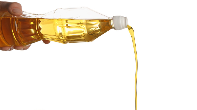 Man pouring cooking oil from a bottle