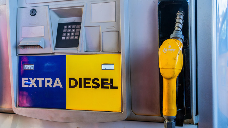 A fuel station pump with a diesel fuel nozzle painted yellow.