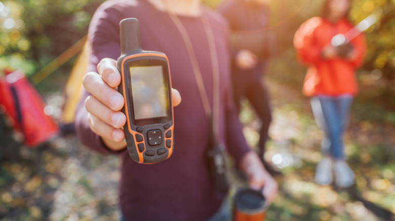 A man holds up a satellite phone.
