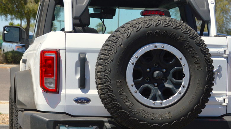 A white Ford Bronco with a spare tire on the back.