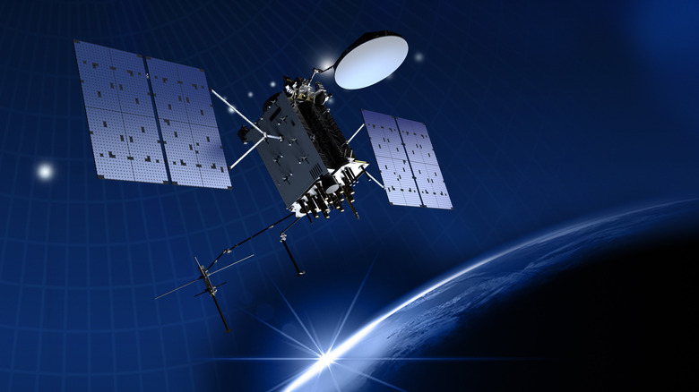 A GPS satellite in Earth orbit with the sun setting in the background