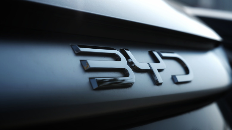 Close-up of a metallic 'BYD' emblem on the dark rear of a modern car, highlighting the sleek numbers and automotive detail. Photo taken in Cigombong, West Java, Indonesia in 07 Jun 2025