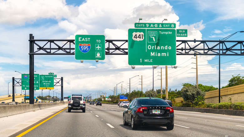 Miami, USA - April 30, 2022: Highway traffic by interstate road 595 east with exit sign to Florida turnpike to Orlando in Miami-Dade county