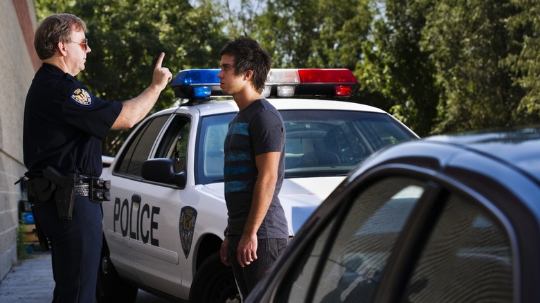 A police officer performing a DUI test with a driver suspected of being intoxicated