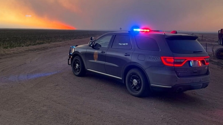 Rear 3/4 view of a Kansas Highway Patrol Dodge Durango on a dirt road with a dusty sunset
