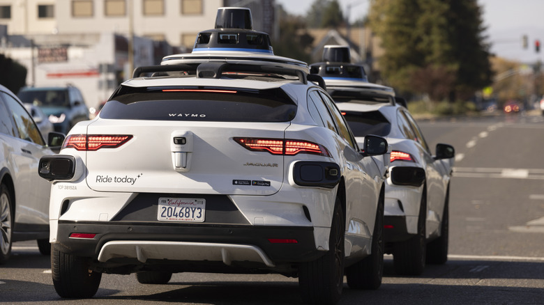 Belmont, California, USA - October 30, 2025: Two Waymo self driving robotaxi cars stop at a stop light.
