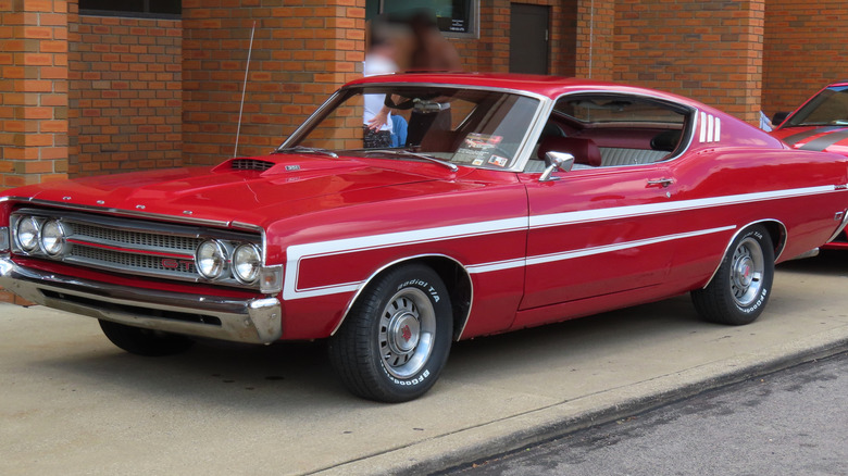 A red 1969 Ford Torino GT parked on a sidewalk