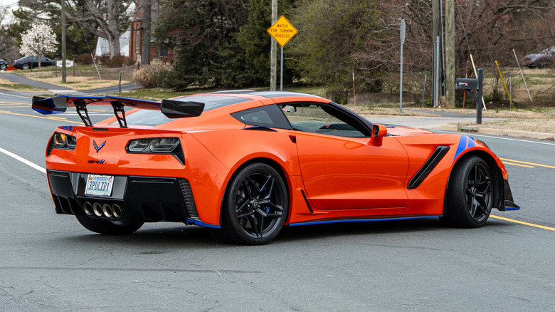 A rear right 3/4 of an orange 2019 Chevrolet Corvette C7 ZR1 making a turn on a public road