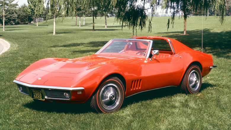 A red 1968 Corvette set in a grassy background, featuring redline tires.