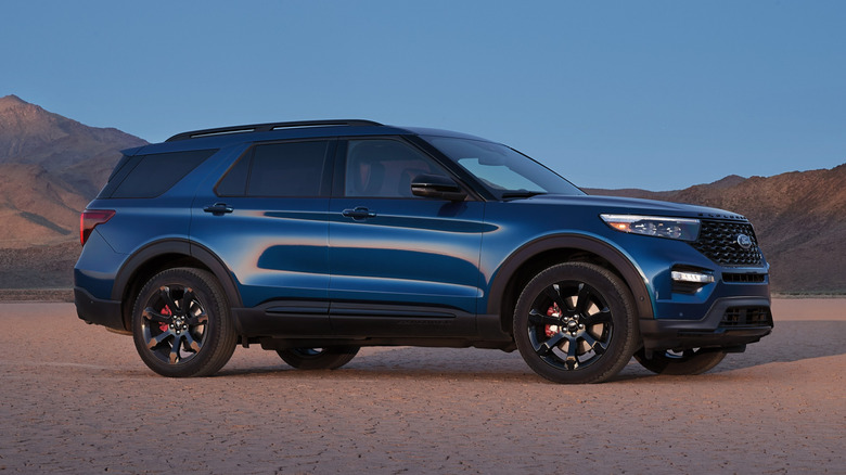 A blue 2022 Ford Explorer ST SUV parked by desert mountains at twilight