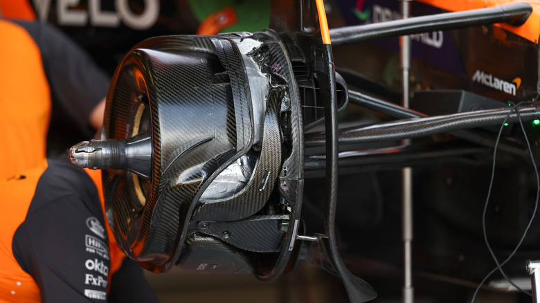 The front disc brake fairing hiding the disc and caliper assembly of an F1 car.