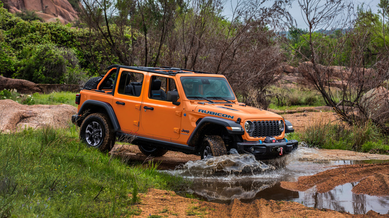 Orange Jeep Wrangler driving through water