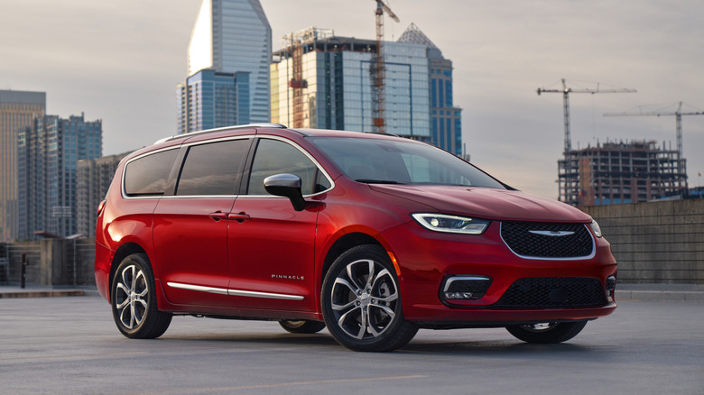 A 2026 Chrysler Pacifica Pinnacle in deep red parked on an urban rooftop at dusk.