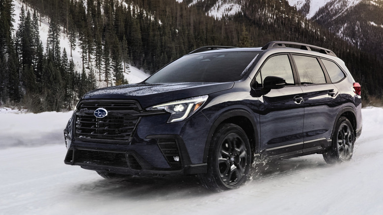 A dark blue Subaru Ascent SUV driving in the snow.