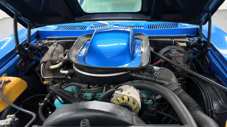 A blue Pontiac GTO has its hood popped to reveal a 350 V8.