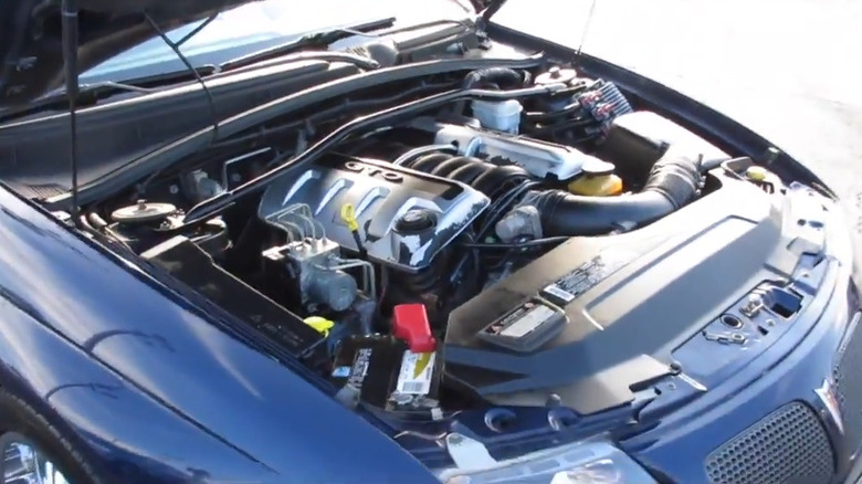 A blue GTO has its hood popped to reveal an LS2 V8.