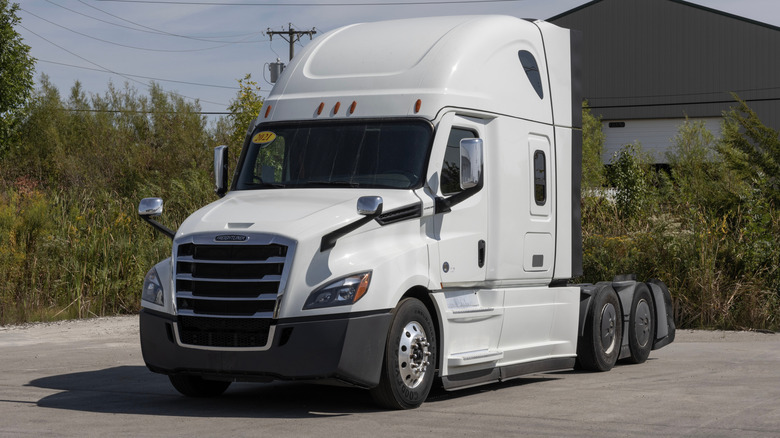 Freightliner Cascadia semi tractor trailer large rig parked connected a paved surface.