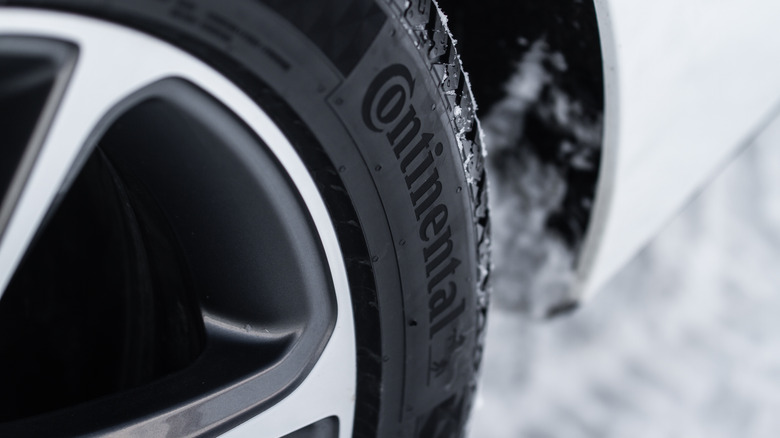 Closeup of a Continental tire on a white car.