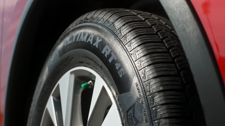 Closeup of an AltiMAX RT45 tire on a red car.