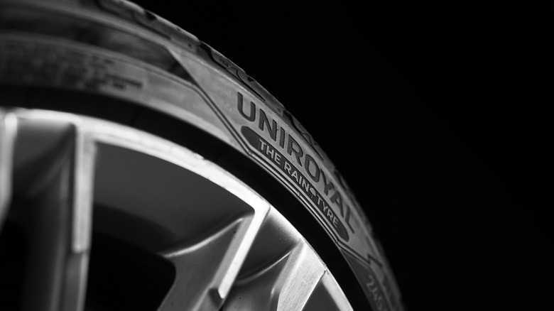 Closeup of a Uniroyal tire on black background.