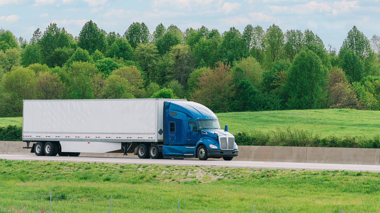 Big rig drives through rural area.